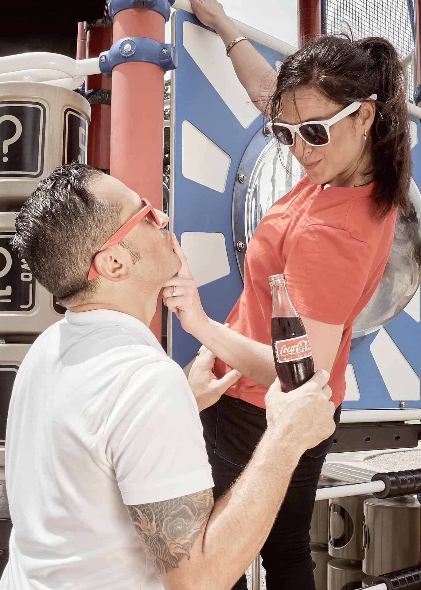 Couple on playground drinking Coca-Cola