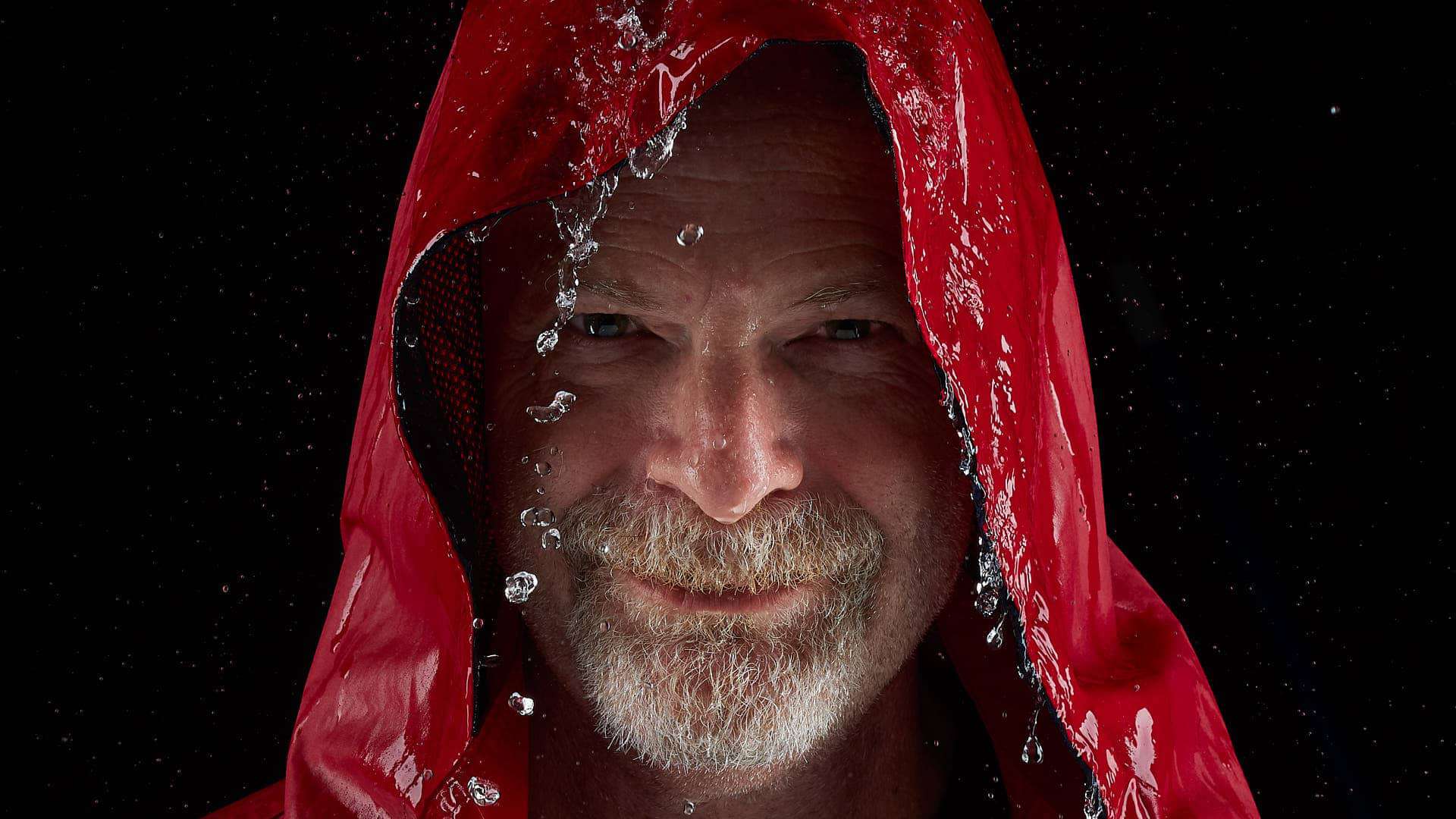 Head shot of Keith Emmons wearing red raincoat.